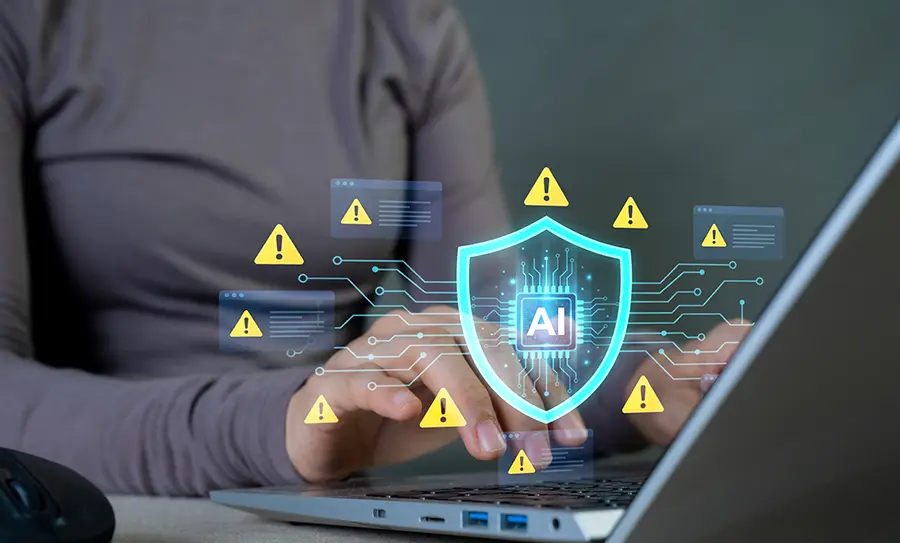 laptop with AI shield and warning icon graphics for cybersecurity and threat protection