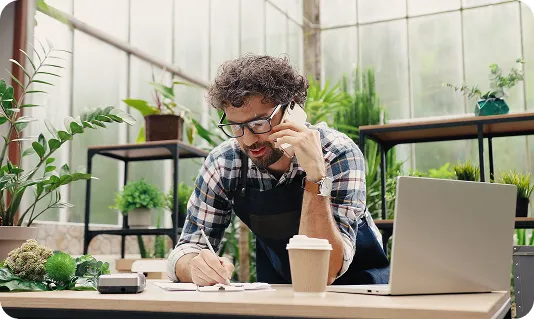 a plant store owner speaking on the phone, taking an order