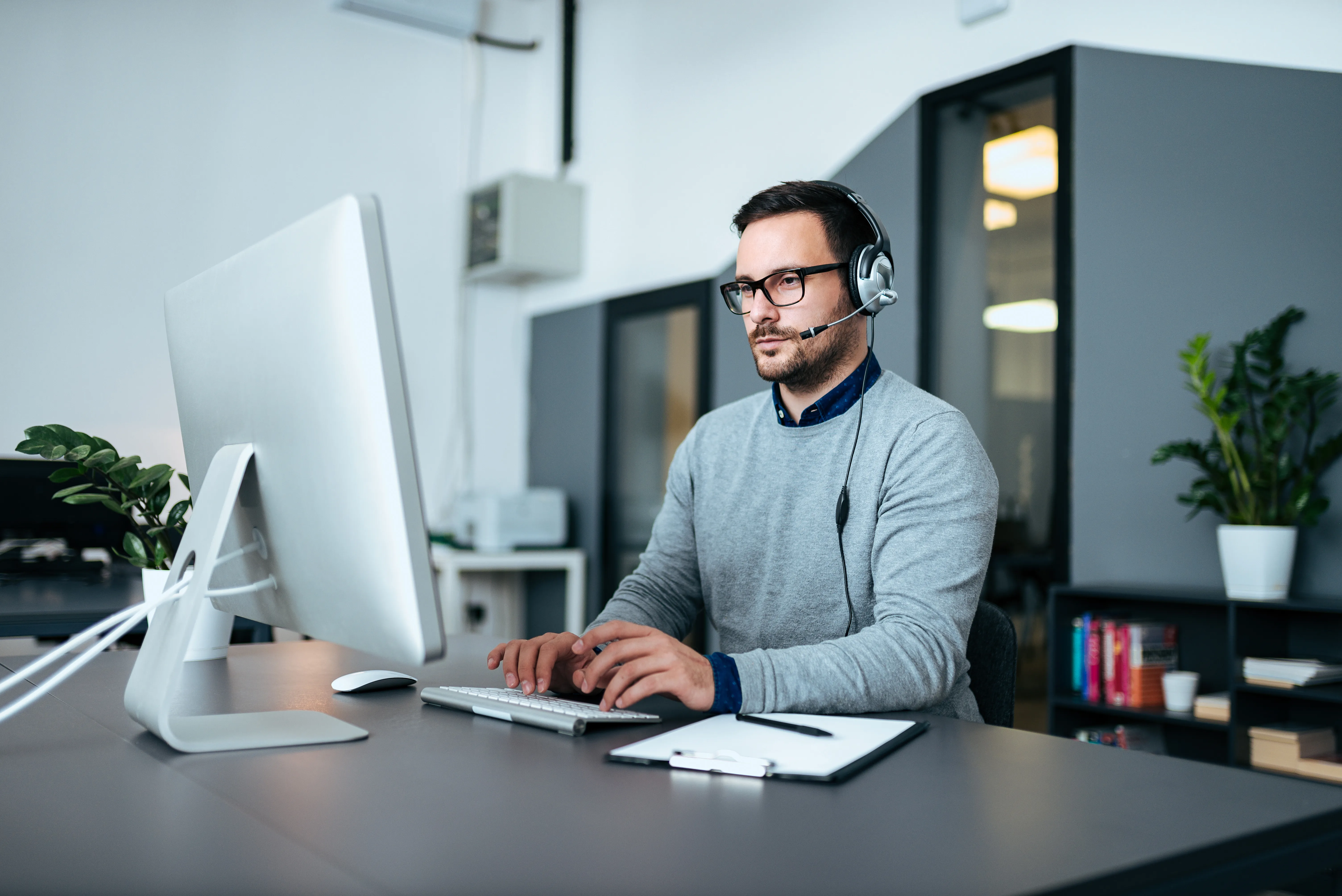 an IT Support specialist smiles while using his computer