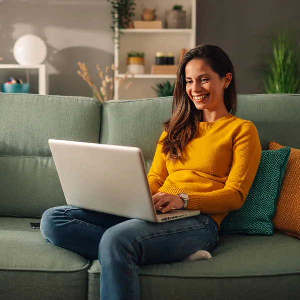 a woman smiles at her laptop